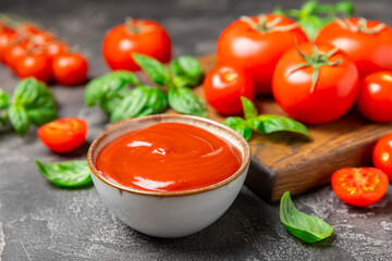 Fresh cherry tomatoes and fresh green basil on a textured background. Tomato sauce. Vegan. Ingredients for salad. Organic food. Place for text. Copy space.