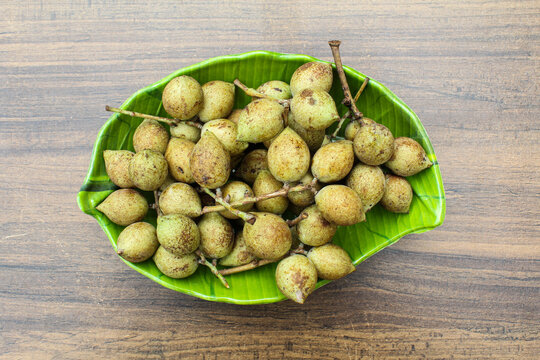 Schleichera oleosa or kusum fruits in a plate on wooden background 