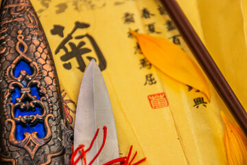 The knife blade lies on a fan with a Chinese character close-up