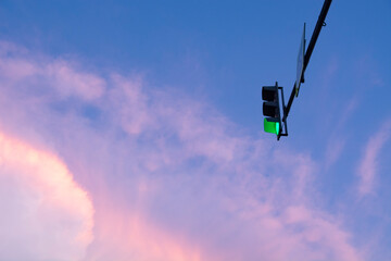 A real majestic background of the sunset sky with delicate multicolored clouds and a traffic light...