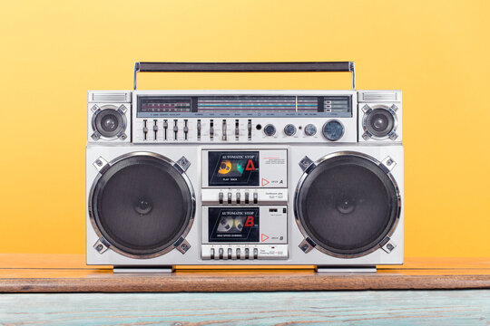 Retro boombox radio cassette recorder from 1980s front yellow background. Vintage old style filtered photo