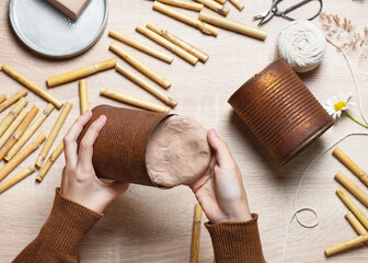 Step 3. Fill a 1-2 cm thick clay layer into the bottom of the can. Create a DIY bug hotel for garden. Kids craft and helping wild animals concept.