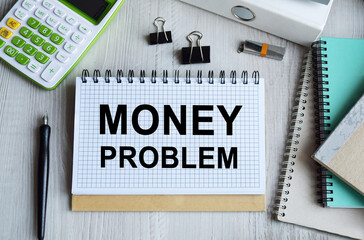 Notepad with the inscription MONEY PROBLEM. Conceptual image, business accessories, calculator isolated on the desktop. Finance or business concept.