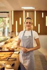 Portrait of a Lovely Blonde Girl, posing for the camera, working at the bakery.