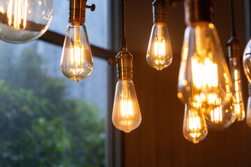 A bunch of light bulbs hanging from the ceiling, some of which are lit up