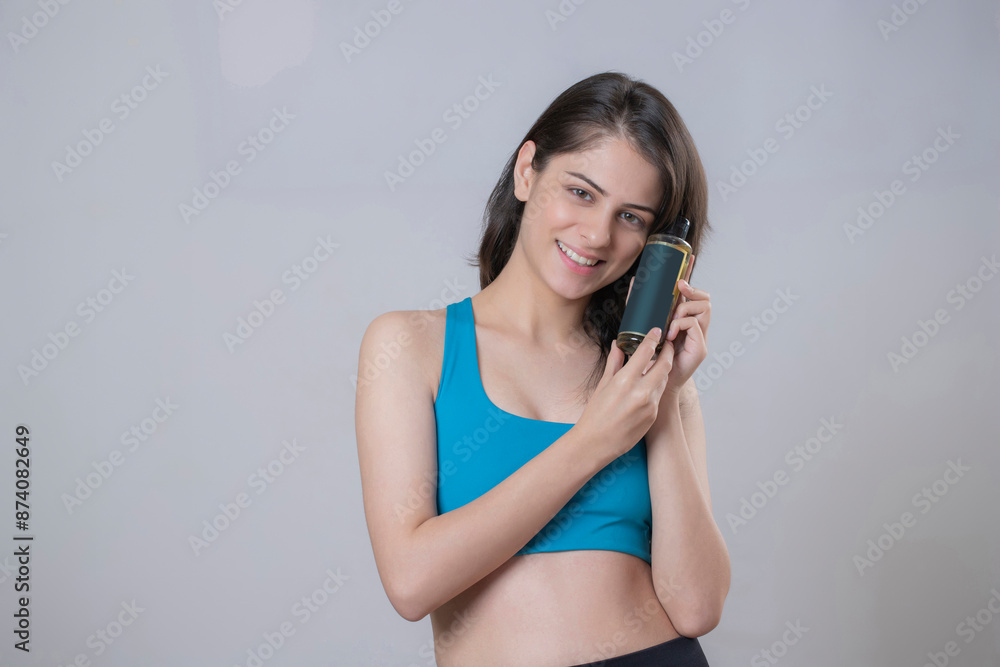 Wall mural gym cute girl with an oil bottle in her hand