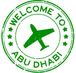Grunge green welcome to abu dhabi with airplane icon round rubber seal stamp on white background