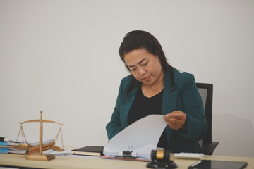 Pretty Asian female lawyer working and hammer, laptop, justice advice and legal concept. In office