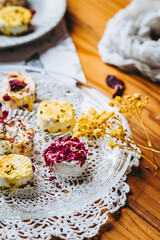 Petits fromages de chèvre frais avec des graines et pétales fait-maison posés dans une assiette