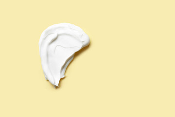 Sample of cosmetic cream on yellow background
