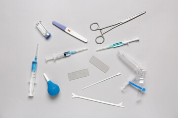 Gynecological speculum with pap smear test tools, syringes and ampule on white background