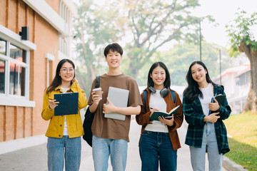 Obraz premium Young people college students is reading a book while relaxing sitting on grass in a campus park