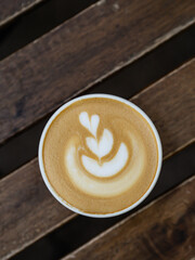 Cup of cappuccino coffee on wood table in outdoor cafe