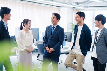 オフィスで立ち話をするビジネスパーソン