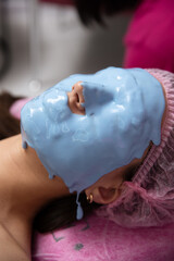 cosmetologist applying a face mask