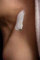 girl smears cream on her skin
