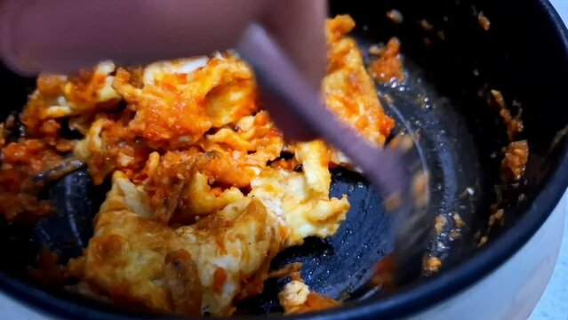 Asian egg and eggplant scramble cooked spicy on a hot pot for breakfast. Indonesia call Telur Orak Arik.
