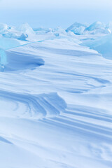 Blue and white abstract natural background of snowy ice surface of Baikal Lake on frosty winter...
