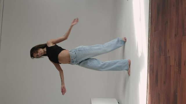 Woman in mid-dance, striking a dynamic pose against a plain background, exuding confidence and grace. Concept: Highlighting the importance of maintaining an active lifestyle and celebrating the