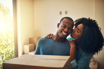 New house, box and happy couple with kiss for moving, real estate or property investment in living room. Lens flare, black man and young woman with cardboard for love, mortgage or relocation in home