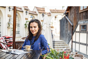 young woman taking tea at cafe 