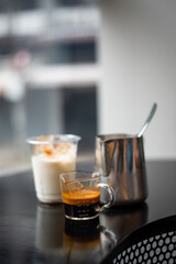 a cup of coffee sits on a table with a black table in the background.