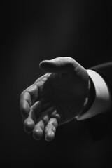A close-up image of a person's hands, depicted in monochrome tones