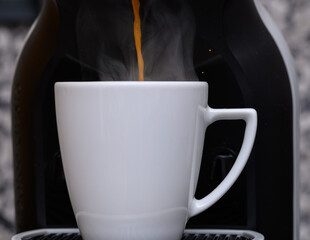 Parzyć kawę, gorący strumień wpada do filiżanki z dyszy ekspresu © Paweł Kacperek