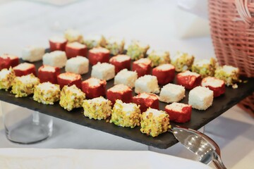 sushi on a plate. catering buffet with variety of food snacks and appetizers.