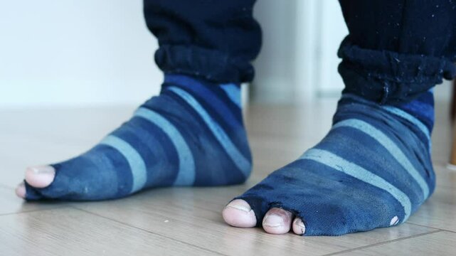 men feet with dirty socks while sitting on sofa 