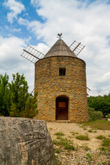 Fototapeta premium Joli moulin provençal, champ d'oliviers et ciel bleu