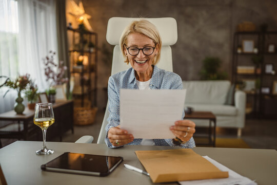 Mature woman work from home read letter post envelope with good news