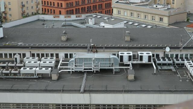 Ventilation and air conditioning systems with air ducts on roof of city building. Blocks with fans and pipes with filters for comfortable indoor microclimate. Top view of flat roof of modern building.