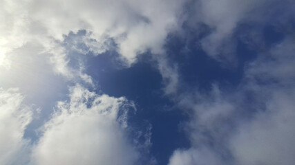 Sun shining through the clouds in a deep blue sky