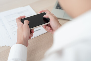 business man use phone to scan barcode or QR codes to pay credit card bill after receiving document invoice online. payment, receive, paying electricity, digital payments without money, technology