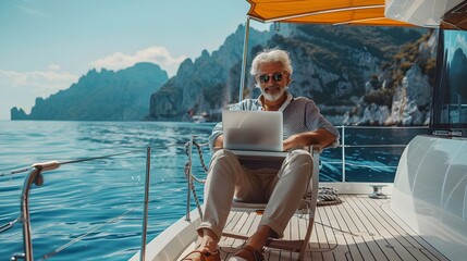 Mature Man Enjoying Laptop on Yacht with Scenic Mountain Lake View