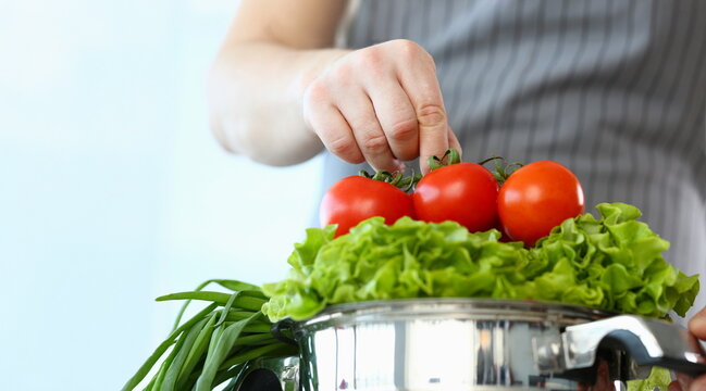 Close-up of chef put ripe tomatoes on lettuce, man cooking new recipe, try vegetarian food. Healthy culinary, hobby, yummy, veg eating, food, eco concept - Powered by Adobe