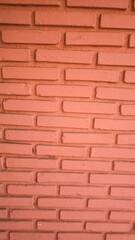 The wall is made of orange bricks.