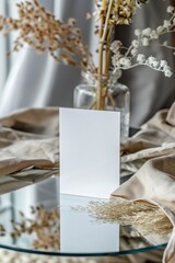 Minimalistic blank card on reflective surface with neutral-toned decor, perfect for invitations, announcements, or marketing materials.