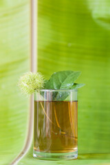 Coffee drink in a glass decorated with flowers and banana leaves.