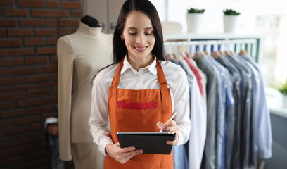 Dry cleaning administrator woman with tablet. Dry cleaning and laundry service concept