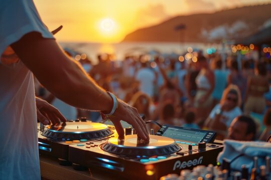 DJ mixes outdoors at a beach party festival with lots of people in the background.