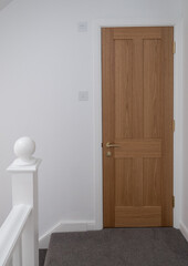 Wooden, shaker style, panelled internal doors with brass door furniture and white painted walls. Part of a house renovation in London UK.