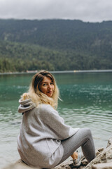 Young woman sitting on a mountain lake