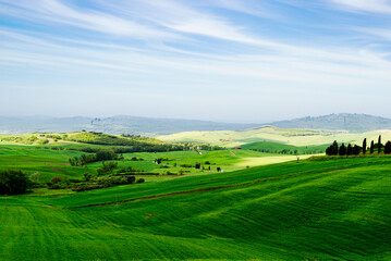 Tuscany, Italy-April 22, 2024: Expansive Green Tuscan Hills Under Blue Sky