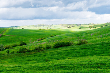 Tuscany, Italy-April 22, 2024: Rolling Green Hills Under Cloudy Sky
