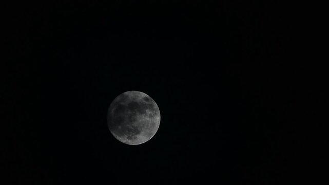 The moon is moving and there are some clouds.