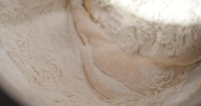 Adding flour to the dough and mixing in the Kitchen machines
