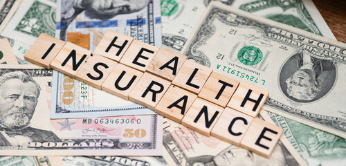 "Health Insurance" Text Against a Background of US Dollar Bills
