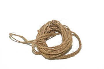 A skein of twine made from natural fibers lies on a white background.